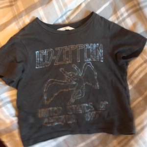 säljer denna asballa baby tshirten med led zepplin tryck! den är i barnstorlek men passar som en croptop för mig som har S!