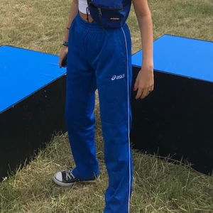 Blå tracksuit-byxor från Asics - Säljer dessa coola blå byxor, långa och raka! 