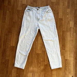 Lee Jeans - (Mått: W31, L33) pösiga “elasticated mom” jeans i väldigt bra skick förutom hålet till knappen vid gylfen som fått små revor. Passform funkar även för W32 då dom är stretchy. Går att mötas upp eller frakta via postnord