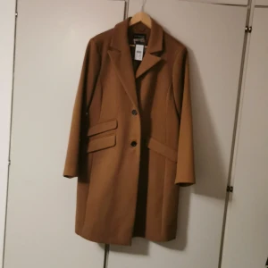 En kappa  - Helt ny kappa i nyskick som är helt oanvänd med prislapp. Säljer på grund av fel storlek. Köpt för 1300. Gratis frakt