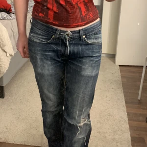 Mörkblå lågmidjade jeans - Ett par jätte snygga  mörkblå lågmidjade jeans med hål i knät.