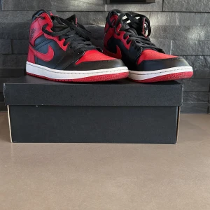 Nike air Jordan 1 mid banned  - Detta är ett par Jordan 1 mid banned i bra skick. De ör använda 10 gånger ungefär. De är storlek 43. Jag kommer sälja dessa för 1000 kronor. Skriv vid intresse.