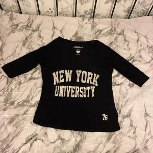 New York University tröja  - En tröja med lite längre tyg på på baksidan än framsidan, har trekvartslånga ärmar
