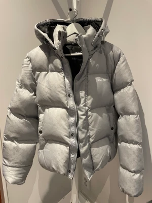 Puffer jacket Daily Paper Strl S - Daily Paper puffer jacka med avtagbar luva. Snygg struktur i tyg, ljusgrå, nytvättat i nyskick