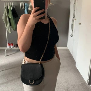 svart väska m. guldkjedja  - Lång, rymlig svart väska med guldskjedja.🖤 Från H&M. Använd ca 10 gånger.🖤