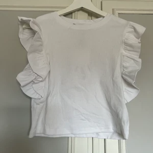 Vit topp - Säljer denna vita topp med volangärm ifrån zara. Tröjan är endast provad eftersom att den är lite för stor för mig. 