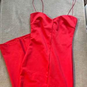 Röd klänning - En fin röd långklänning ifrån Nelly. Säljer då den inte kommer inte till användning. Det är en tajt klänning med en kort slits baktill och smala band. Sitter jättefint på och superbra material❤️