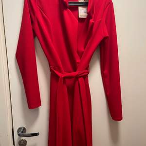 Klänningen är röd och är i storlek 40. Köpt för ca 1 månad sedan och helt oanvänd sedan dess. Köpt för 280kr. Klänningen går även att använda som kappa/blazer 