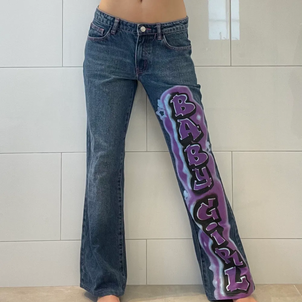Lågmidjade flare/bootcut jeans från märket Jaded London med coolt graffiti print på ena benet och fina härtan på bakfickorna💖 Köpt second hand och tror dom är upsydda men annars nästan som nyskick🌟 Storleken är W25 och jag är 162cm, skriv för mått💙. Jeans & Byxor.