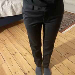 Svarta lågmidjade kostymbyxor - Säljer ett par svarta lågmidjade kostymbyxor som är helt felfria och aldrig använda. Köpta för 899.  