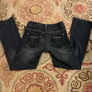 Lågmidjade jeans - Jättecoola lågmidjade jeans med stenar på. Inga tydliga defekter förutom att en sten saknas på ena bakfickan men det är inget man tänker på.  Midjemått: 78 cm Innerbenslängden: 80cm