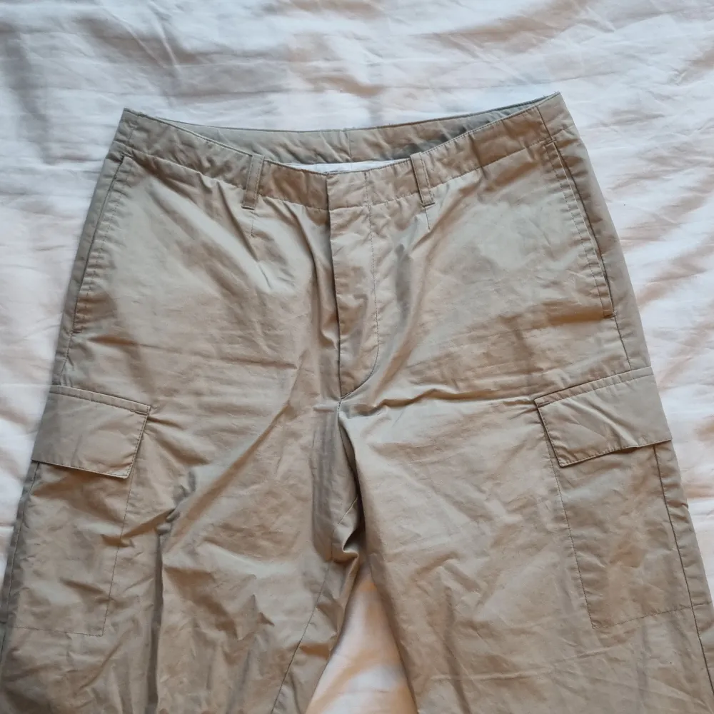 Beige cargobyxor med fickor på sidorna. Herrmodell strl S men passar bra på tjejer oxå. Köparen står för frakt.. Jeans & Byxor.