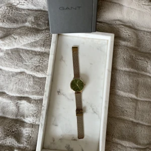 Gant klocka - Säljer denna superfina Gant klocka med grön urtavla och guldfärgad länk. Helt oanvänd! Reglerbar länk. Nypris 1890kr