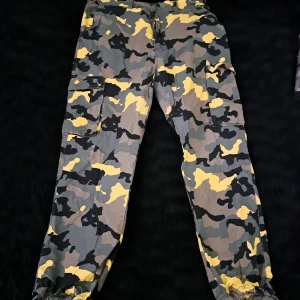 Camoflage cargobyxor - Jättecoola cargobyxor i gröna toner samt gula. Köpta på lager 157 från början. Inte jätteamvända då jag växte ur dem vödigt snabbt efter jag köpte dem