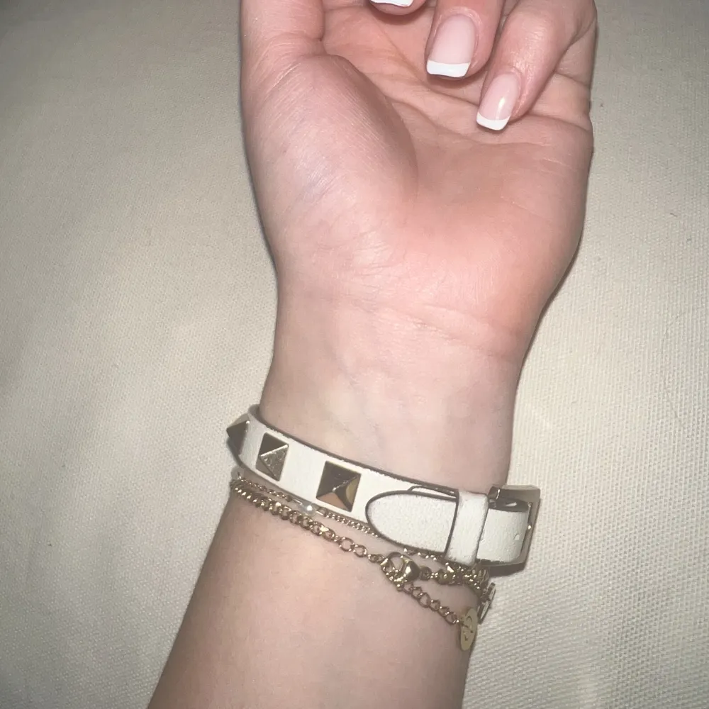 Säljer mitt valentino armband som inte kommer till användning längre. Armbandet är vitt med guldiga nitar. Köpt 2019 för 1900kr men ej använt mycket. Den är justerbar och i fin kvalite! 💕. Accessoarer.