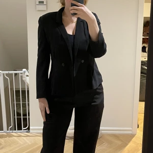 Svart, figursydd blazer - Figursydd blazer, okänd storlek och ursprung men passar en storlek 36/38.