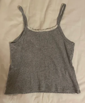 Grått brandy linne - supergulligt linne från brandy melville med lite vit spets! frakt ingår inte i priset, kan mötas upp i tc men postar helst💓materialet är ganska stretchigt👍