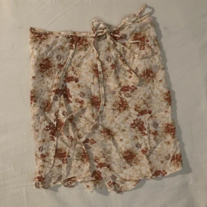 Omlottkjol - Säljer denna jättegulliga omlottkjol med rosa/orangea blomstermönster på. Från sellpy