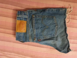 Levi's 501 booty shorts  - Ett par korta Levi's shorts i strlk W26 med knappar i gylfen. Kan tyvärr inte ta bild med dem på pga för små.:(