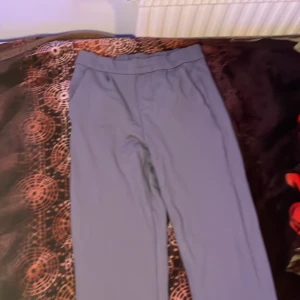 Tajta Kostymbyxor - Här har jag ett par gråa tajta kostymbyxor som jag aldrig har använt. Bakfickan är inte äkta vilket betyder att det inte går att öppna men framfickan är riktig. 