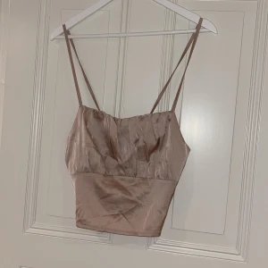 Topp - Beige topp från Shein med öppen rygg, man kan justera snörena lite hur man vill. Storlek M, 50kr+frakt