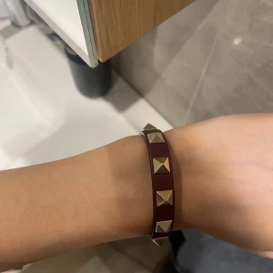 Valentino armband - Säljer mitt vinröda valentino armband i nyskick! Inga defekter. Kan mötas i centrala Stockholm 💛