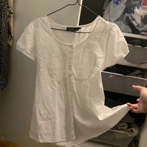 Vit topp - En vit topp från Kappahl i storlek 46, har själv 38 å den passa helt okej om man gillar det lite luftigt! Använd ett fåtal gånger, säljer för de börjar bli fullt i min garderob som man ser i bakgrunden på bilden! Jag står inte för frakten.