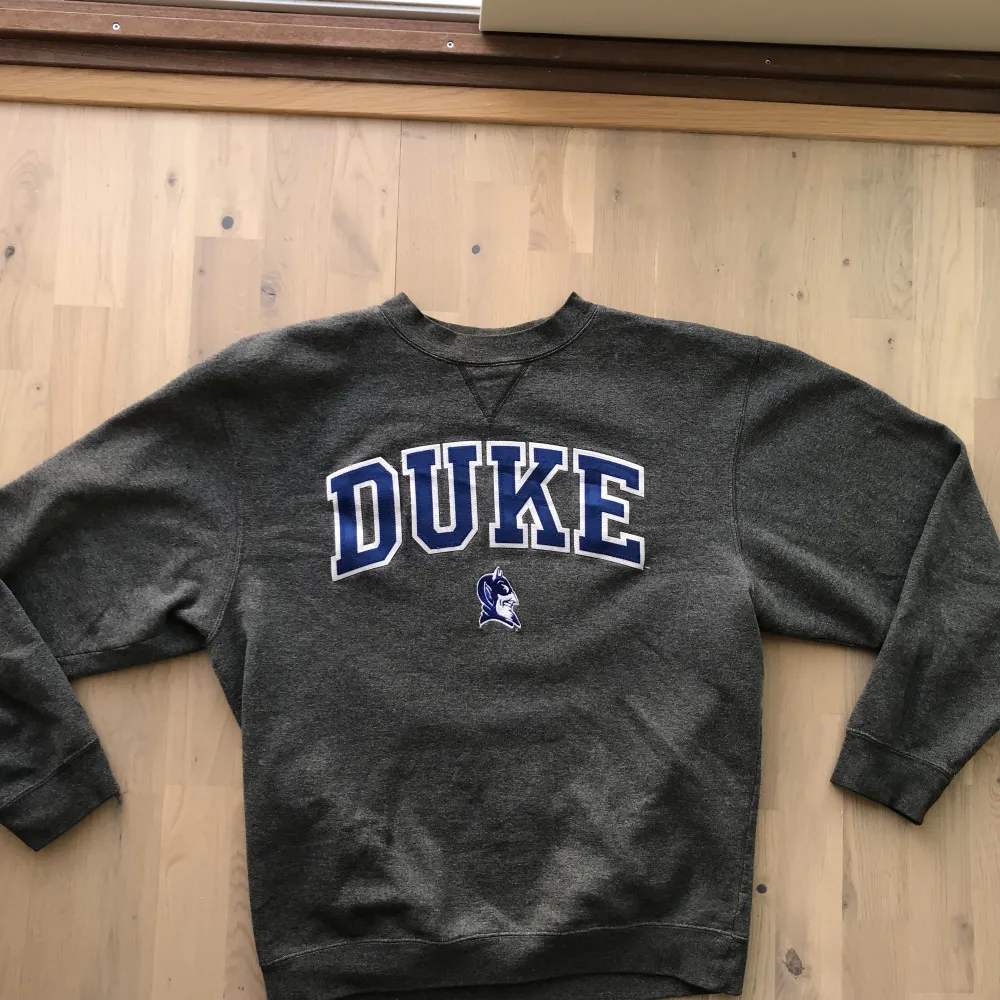 Grå sweatshirt med Duke text på magen. Bra skick. Storlek M. Köparen står för frakt📦. Hoodies.