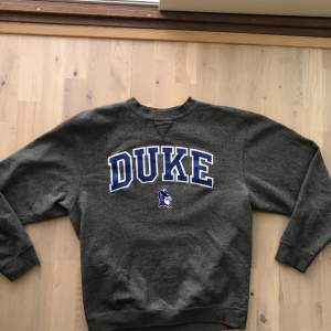 Grå sweatshirt med Duke text på magen. Bra skick. Storlek M. Köparen står för frakt📦