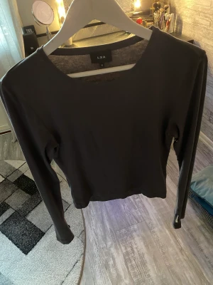 Topp - Grå långärmad topp från LXA med hål för tummarna vid ärm slutten. Storlek M. 200kr.