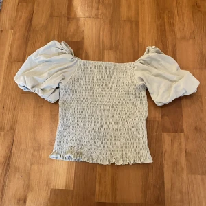Smockad blus - Ljusgrön smockad blus från ginatricot i storlek S. Puffiga ärmar och tröjan är i normallängd. 