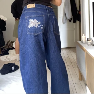 Slutsålda NAKD jeans - Snygga baggie jeans med snyggt tryck på rumpan. Storlek 42 men har lagt till en knapp så att de blir mindre (knappen går att ta bort)