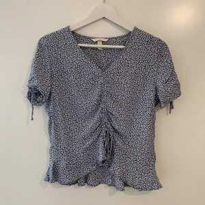 Blommig blus, H&M. Strl. 36 - Blommig, ljusblå blus/topp från H&M i storlek 36. Fint skick!
