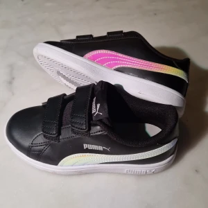 Puma sneakers storlek 30 svarta metallic  - Svarta Puma sneakers i storlek 30. Enbart använda 1 gång, väldigt fint skick. 