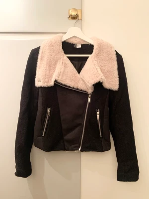 H&M Jacka i Bikermodell skön till hösten 🍂 - Svart jacka i bikermodell i ull samt mocca imitation och beige päls från Divided H&M. Säljs då den inte används. 
