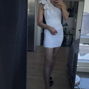 Vit oneshoulder klänning - Vit one shoulder klänning. Använd en gång. Perfekt till studenten.