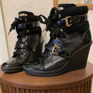 Michael Kors Wedge sneakers  - Svarta wedge sneakers i skinn/mocka i storlek 38. Modellen har hög klack. Nyskick.