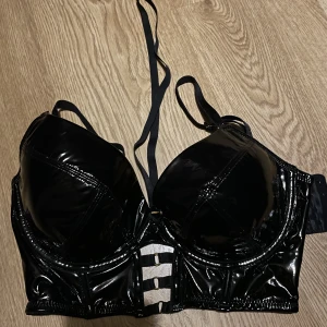 Bh-topp - Säljer denna då den inte kommer till användning🖤använt den 1 gång🖤Köpt på hunkemöller för 479kr🖤Skön att ha på sig då det är ”vanligt tyg” under de glansiga tyget🖤OBS! Jag har 80D vanligtvis o denna passar perfekt då den är lite större i storleken🖤