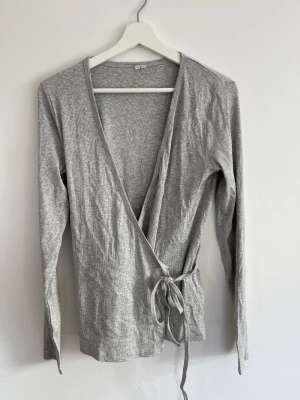 Omlott tröja från ARKET - Ljus grå tunn ribbad långärmadtröja från ARKET strl L men går att reglera tackvare omlott funktion 