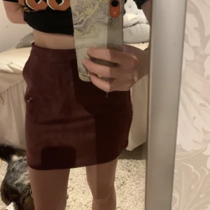 Mocka kjol - Vinröd mocka kjol, har fickor i fram och dragkedja bak. Är XS men känns mer som en S. Aldrig använd 