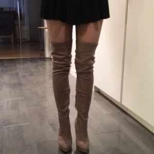 Lårhöga klackskor  - Lårhöga klackskor i mockaimitation. Aldrig använda. Storlek 37.