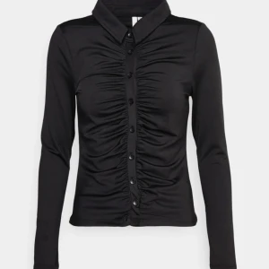 Svart topp - Svart topp/skjorta från Nelly i storlek XS, väsldigt skönt material och precis samma som på bilden.Total pris = 115kr frakt inkl 🤍