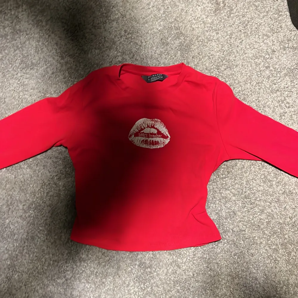 en jättefin röd Primark tröja med tryck där fram. använd ett fåtal gånger och köpte den när jag var i London förra året (september) trycket är en mun där det står ”heart breaker”. skriv privat för mer bilder❤️. Toppar.