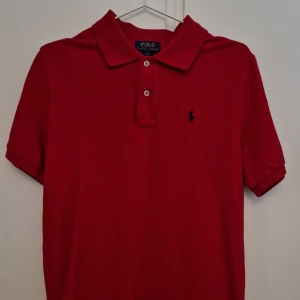 POLO Ralph Lauren Piké röd - Säljer min i princip oanvända Ralph Lauren Piké. När jag fick den var den alldeles för stor, och när jag växte i den hade jag slutat ha på mig Pikéer. Den är i amerikansk juinor strlk L, och sitter som en M. Helt utmärkt skick!