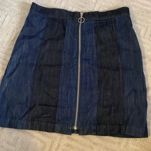 Denimkjom - En denimkjol från HM i mediumlängd/lite kortare Stängs med helt dragkedja. Skriv för fler bilder❤️ Köptes för flera år sedan men är i nytt skick. Den har hög midja. Spänner åt magen och midjan bekvämt. Perfekt till sommaren. Går att styla lätt🥰