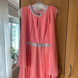 Balklänning - Långklänning i färgen rosa/persika i storlek 36 från märket Luxuar Limited. Nypris 2500kr säljer för 800kr! Använt en gång till bal.   Fint tyg och vackert strass längs midjan och vid halsen.   Det ingår en tunnare sjal som kan användas över axlarna.