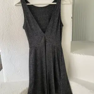 Stretchig och superskön klänning från H&M. Svartglittrigt tyg med en V-ringning i bak. Aldrig använd och är i storlek 34, men passar även större storlekar då den är väldigt stretchig.