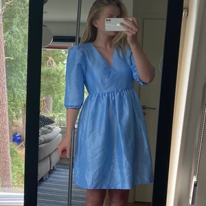 Blå klänning strl M - Söt klarblå klänning i skimrande tyg, strl 36. Köpt från Monki, använd en gång. 