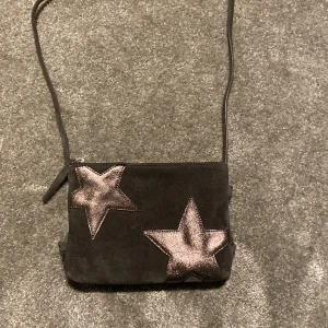 Väska med stjärnor - Jättefin grå väska med stjärnor från Next. Köpte på zalando för några månader sen men bara använd en eller två gånger då den inte riktigt var min stil. Nypriset tror jag var ungefär 500 och jag kan tänka mig diskutera pris💞 hör av er vid intresse