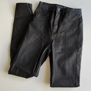 Vaxad byxa strl XS/32 - Snygg, vaxad byxa från VeroModa. Storlek XS/32. Använda men i bra begagnat skick! Väldig stretchiga och sköna. Midja:64cm Innerben:70cm. 